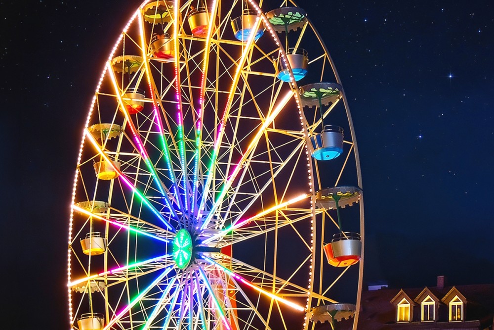 Nachtaufnahme eines Riesenrads mit bunten Lichtern auf der Michaeliskirchweih.